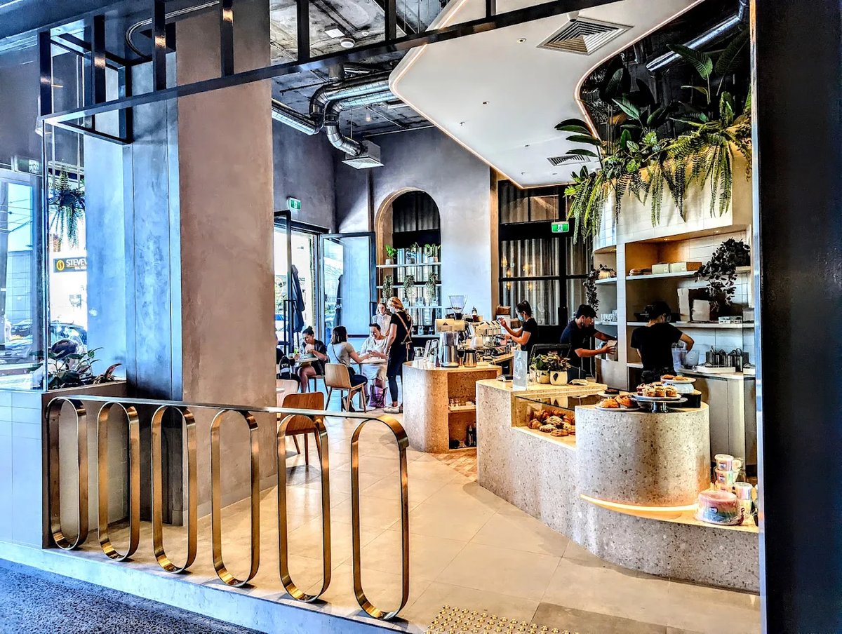 Au79 storefront with terrazzo counter, hanging ferns and brass bike rack