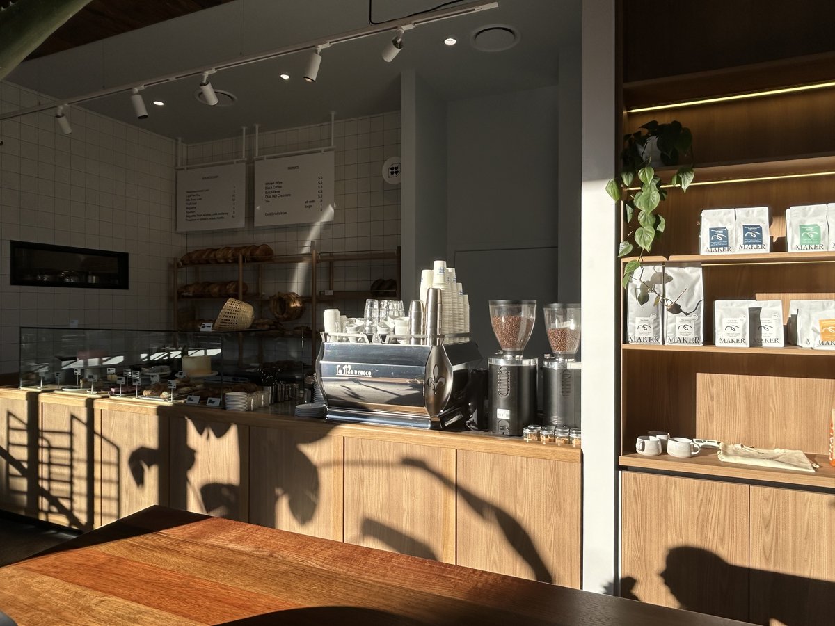 Coffee counter with La Marzocco machine and Maker coffee bean bags on shelving