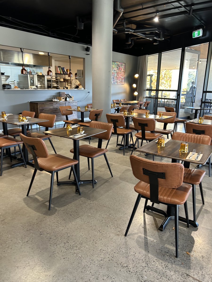 Bon Martin dining room with tan leather chairs and an open kitchen view
