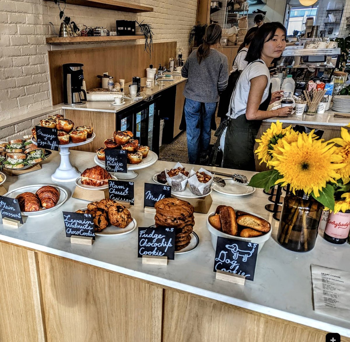 Pastry counter with croissants, cookies and sunflowers at Heart Coffee