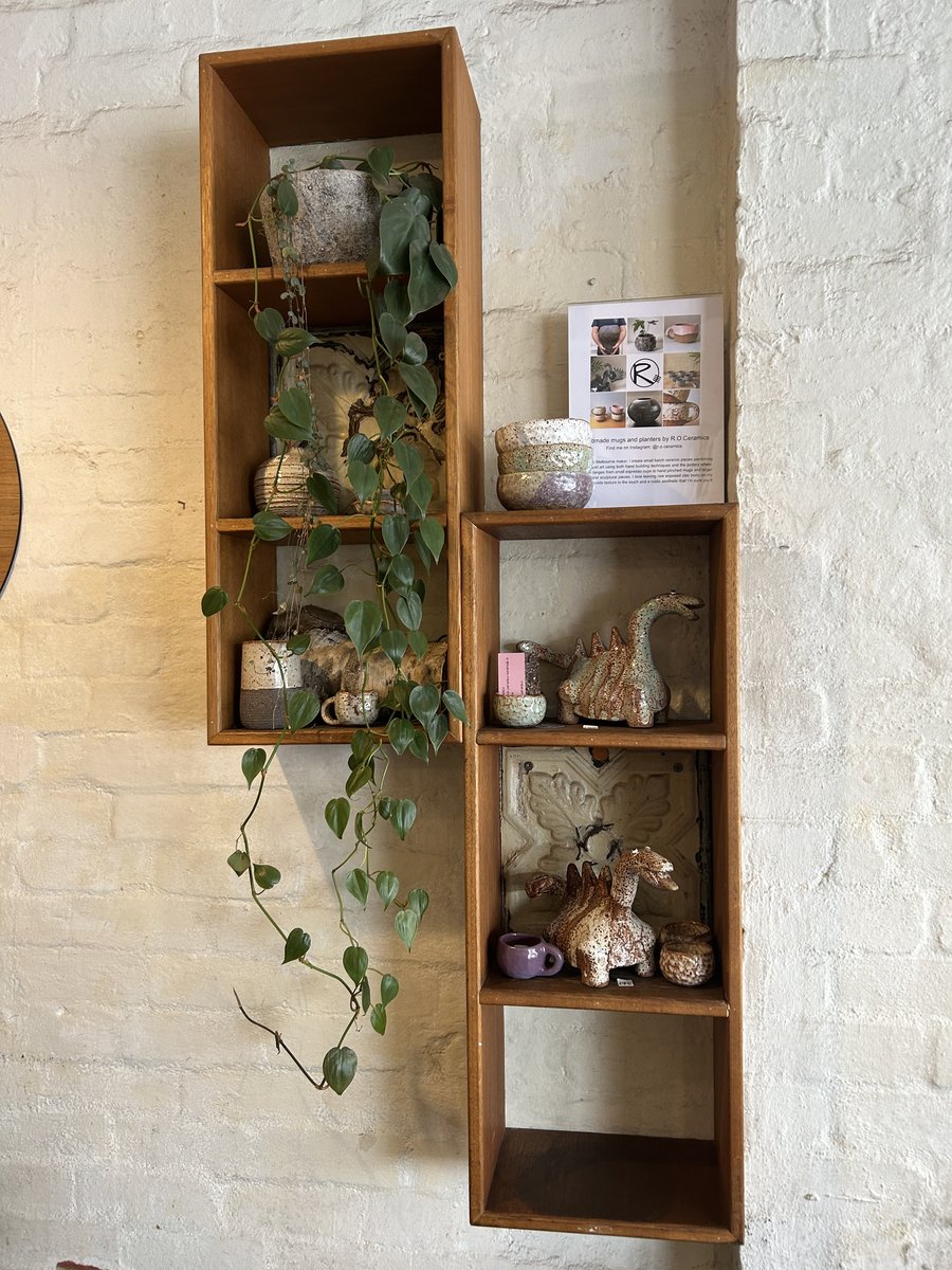Handmade ceramic mugs and ornaments displayed on a wall shelf at LumberJack