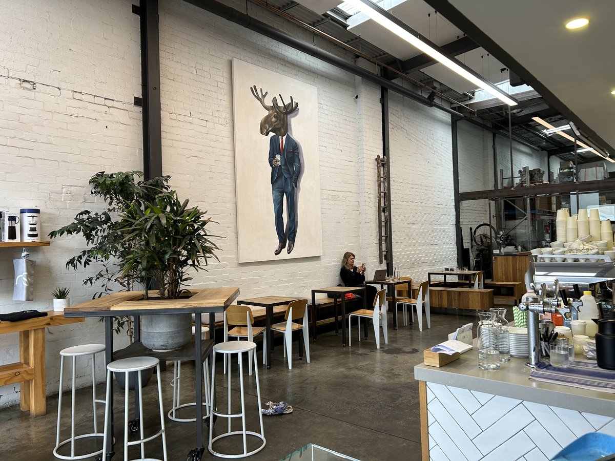 Maker café seating area with moose-in-a-suit mural