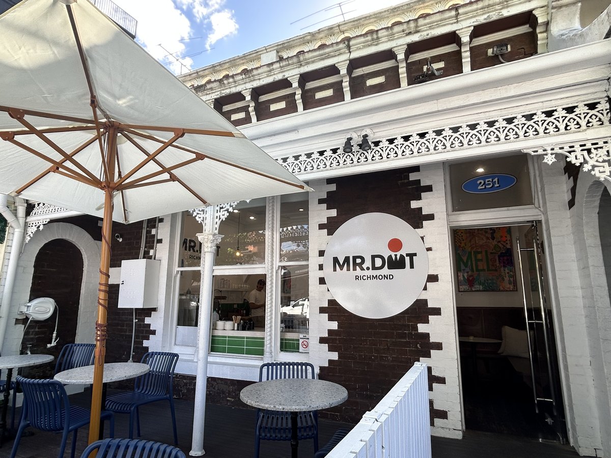 Mr. Dot Richmond storefront with round logo signage and outdoor umbrella seating