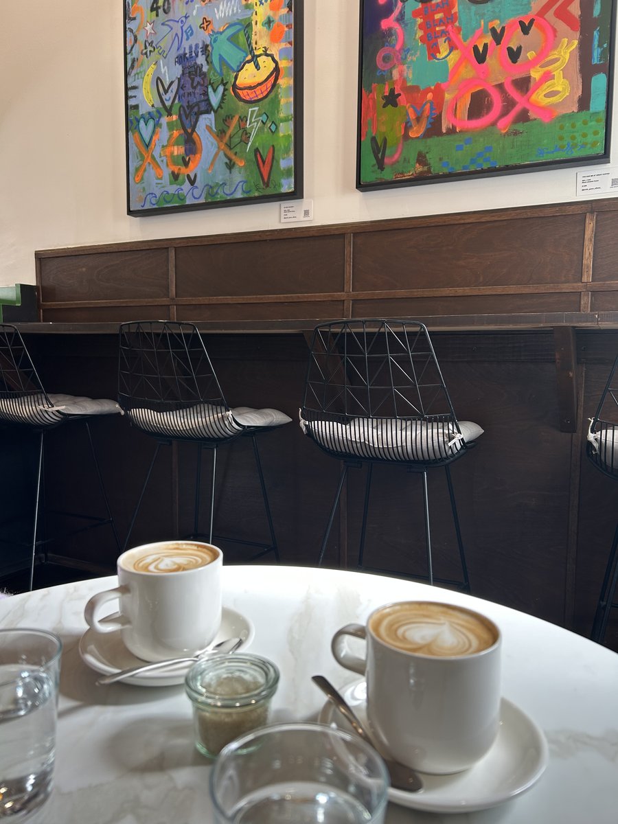Two lattes with heart-shaped latte art on a marble table at Mr. Dot Richmond