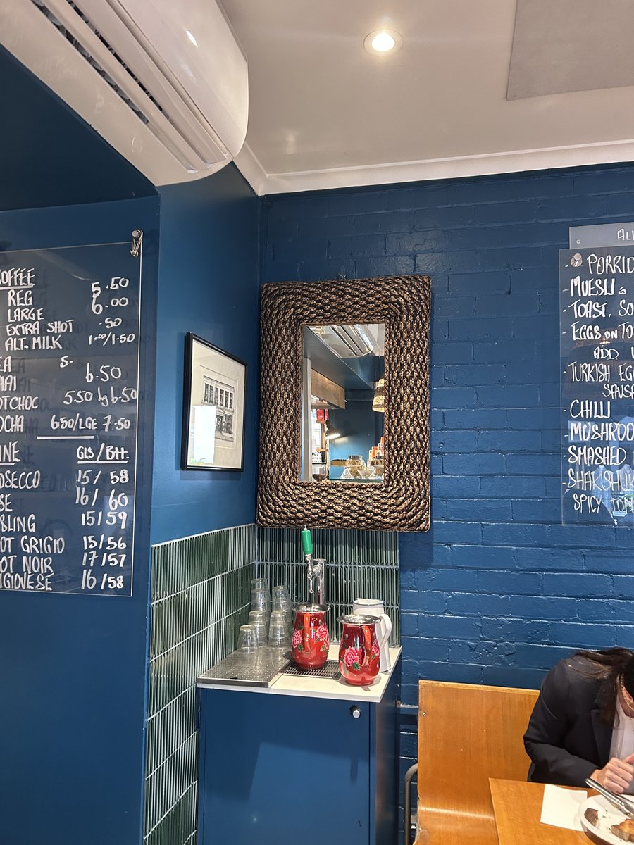 Otello Espresso interior with blue brick walls and chalkboard menu