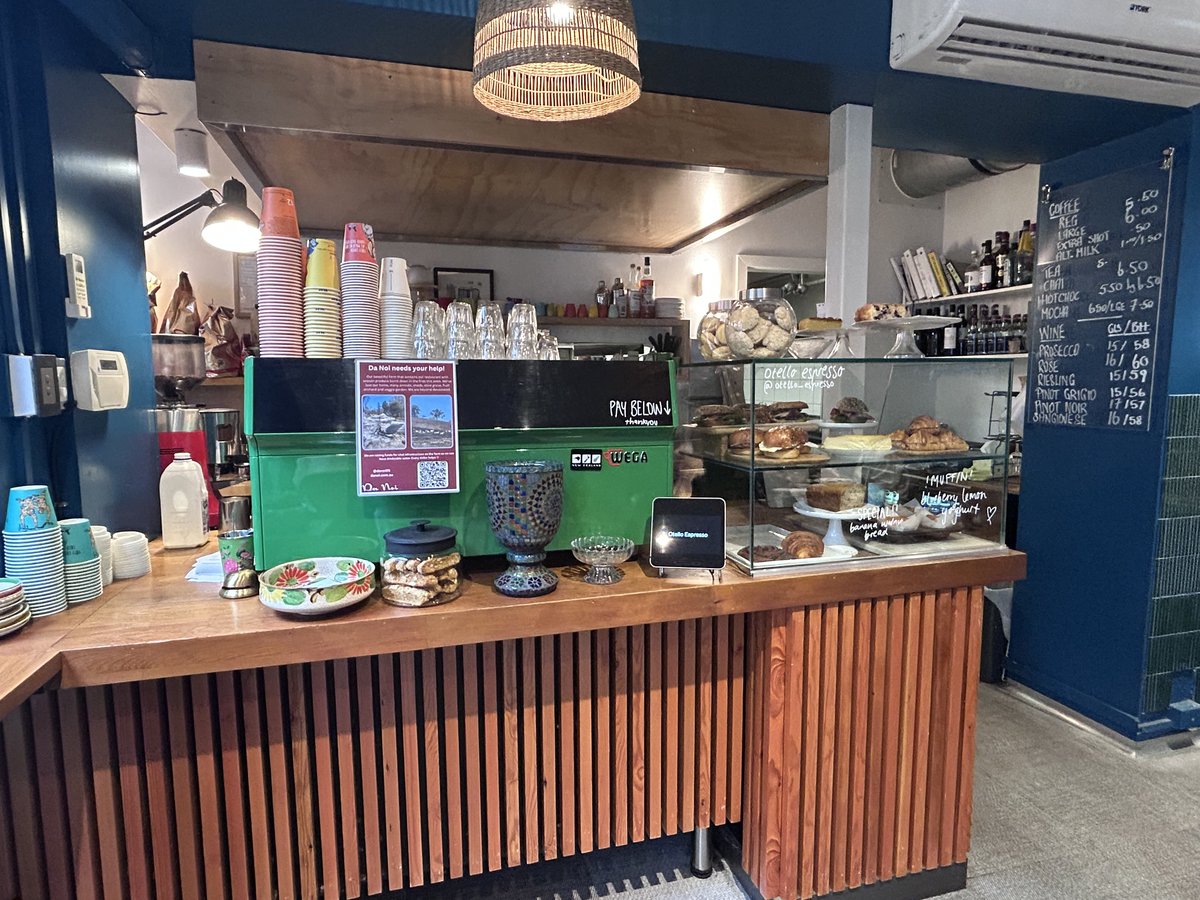 Otello Espresso counter with pastry display and green coffee machine