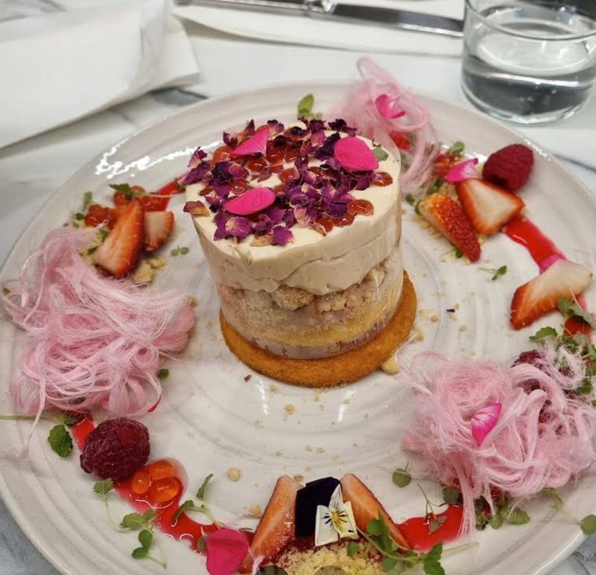 Decorative dessert plate with pink spun sugar and rose petals at Riche
