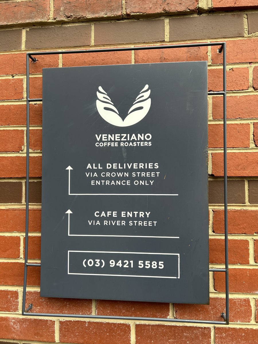 Veneziano Coffee Roasters signage on red brick wall