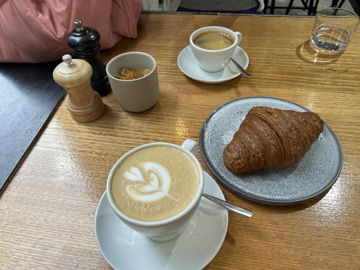 Coffee and croissant on a table at Veneziano Coffee Roasters